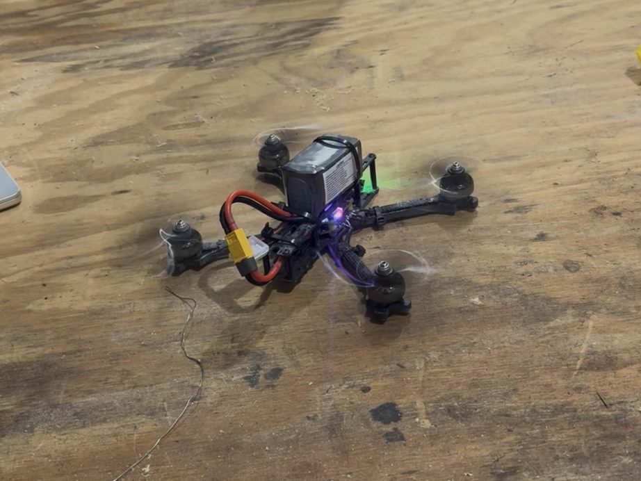 The quadcopter testbed powered up on a workbench with all four motors spinning