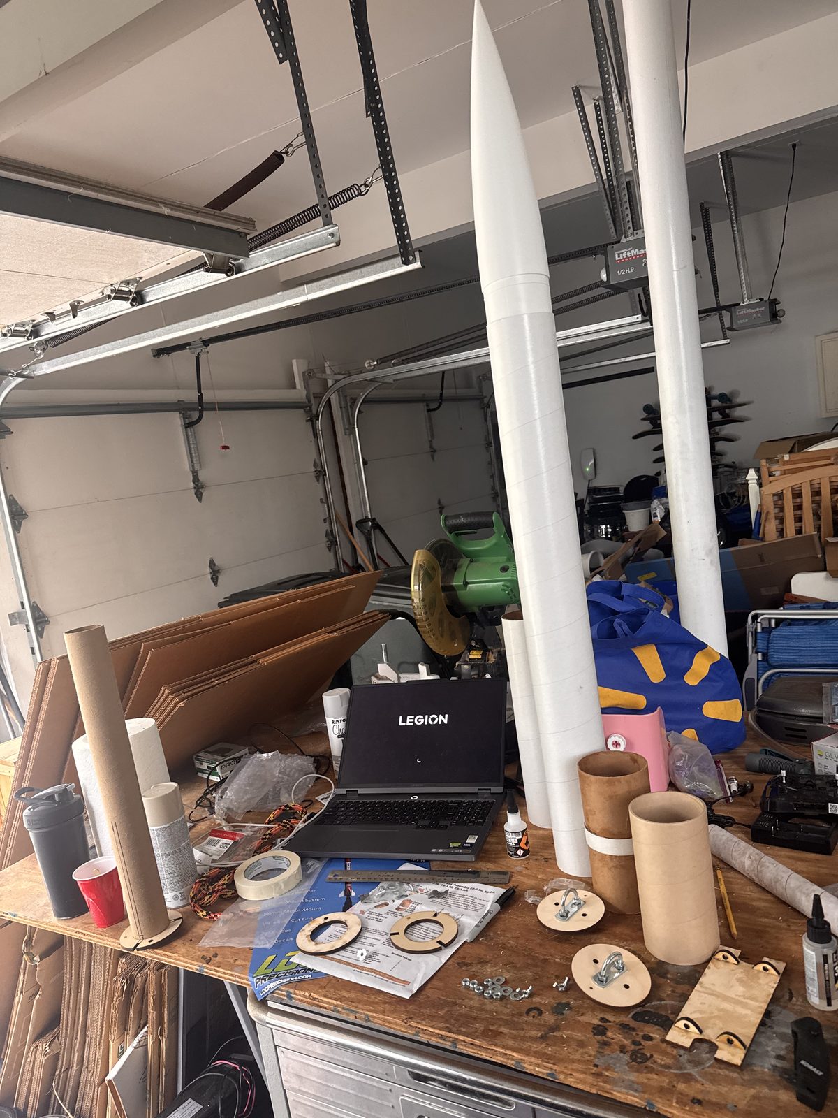 The primed airframe on the workbench alongside body tubes, centering rings and motor mount hardware
